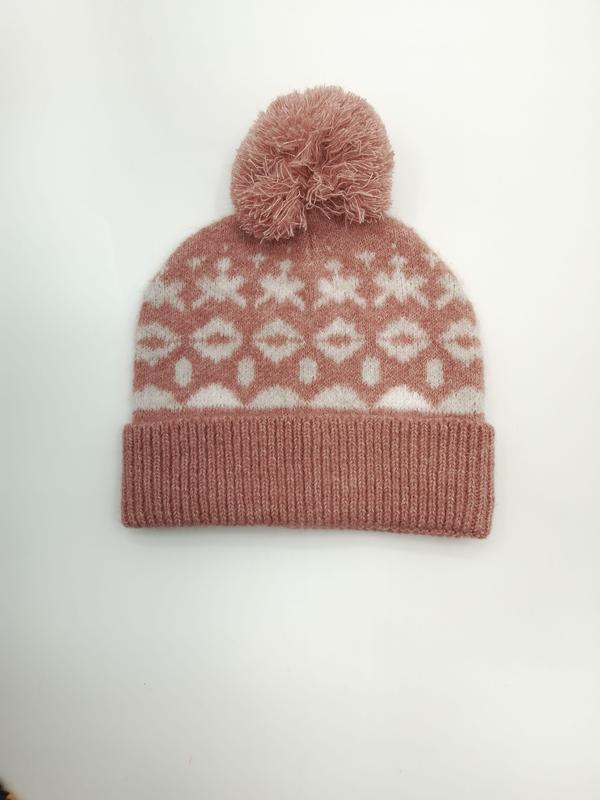 Roze gebreide Fair Isle muts met witte sneeuwvlokpatronen en pluizige pompom