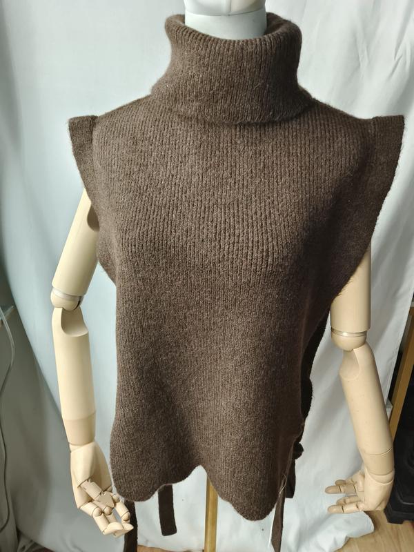 Bruine grove gebreide mouwloze col-trui vest met geschulpte zoom en zijstrik op paspop.