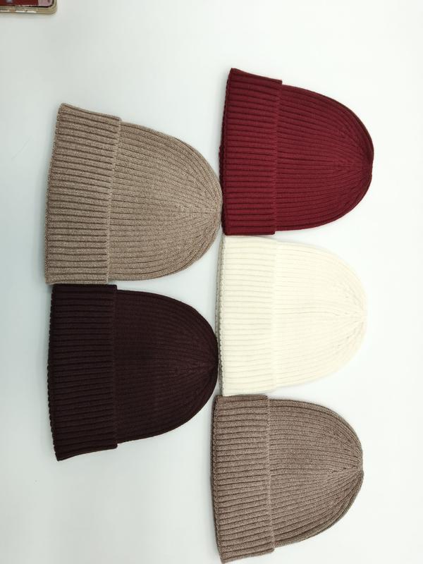 Vijf geribbelde gebreide mutsen plat neergelegd in beige