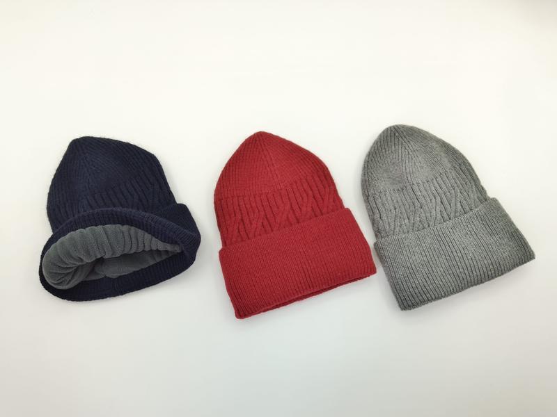 Drie geribbelde fleece-gevoerde muts in marineblauw, rood en grijs op witte achtergrond, met zichtbare grijze voering.