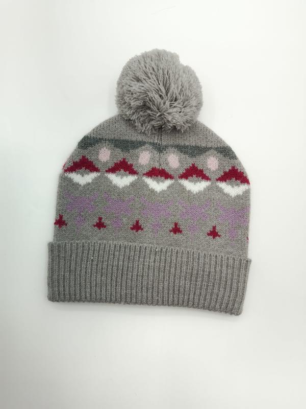 Grijze gebreide beanie met pompon en Fair Isle-patroon in rood, wit, roze en paars op witte achtergrond.